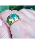 Men's 18K yellow gold ring with a rectangular Colombian emerald in a full bezel setting.