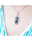 Watermelon tourmaline pendant with diamonds in 18K white gold on a woman's neck.