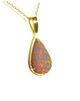 Pear-shaped Australian opal pendant with fiery red/orange hues in 14k yellow gold setting and chain.