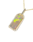 Opal pendant with gold and diamonds frame on a left-side position.