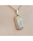 Opal pendant necklace on a person's chest.