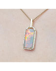 Opal pendant necklace on a beige skin background.