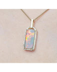 Opal pendant necklace on a beige skin background.