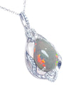 Teardrop-shaped opal pendant with silver chain on a right-side profile view.