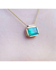 slider solitaire necklace with a Colombian emerald east west orientation set in a handmade setting in 18k yellow gold