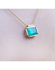 slider solitaire necklace with a Colombian emerald east west orientation set in a handmade setting in 18k yellow gold