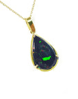 Teardrop-shaped Ethiopian black opal pendant with gold setting on a right-side profile view.