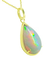 Opal pendant necklace with gold chain on a right-side profile view.