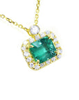 Emerald necklace east west orientation encircled in a halo of natural diamonds, crafted in 14k yellow gold