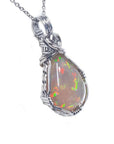 Welo Ethiopian multicolor opal pendant with pinpoint colors, wrapped in handmade silver wire.