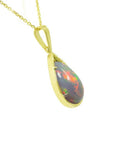 Pear-shaped Ethiopian Welo opal pendant with fiery red-orange play of color, set in 14K yellow gold.