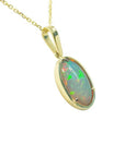 Oval Ethiopian opal pendant with bluish green hues, prong-set in 14K yellow gold.