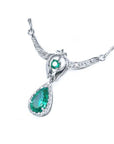 Right side view of a woman's emerald necklace May birthstone pear-shaped halo diamonds 14k white gold