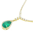 Right side of a real emerald necklace pear cut natural crafted in 18k yellow gold, encircled by a halo diamond
