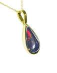 Teardrop Welo black opal pendant with red-orange and blue-green flashes in 14K yellow gold.
