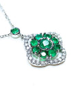 Right view of a 14k white gold necklace with green round cut emeralds cluster pendant on a white background