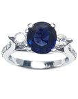 A women’s natural blue sapphire ring featuring three stones in white gold, and accent natural diamonds prong-set in Lucida style.