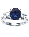 A women’s natural blue sapphire ring featuring three stones in white gold, and accent natural diamonds prong-set in Lucida style.