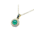 14K yellow gold minimalist necklace with a round-cut Colombian emerald and natural diamond halo pendant.