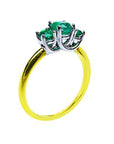 From a partial side angle, this emerald ring reveals the top setting, a portion of the gallery, and the band design.