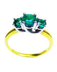 This emerald ring displays the top three stone setting and band perspective.