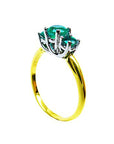 From a partial side angle, this emerald ring reveals the top setting, a portion of the gallery, and the band design.