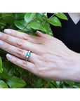 1.38 ct. round emerald ring with side diamonds in 14K white gold on a hand.