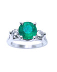 Top view of a round cut colombian emerald ring with side natural diamonds in white gold