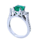 On top a round cut emerald and downside profile half side view of this emerald ring.