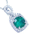 Emerald pendant with diamond accents on a right position topside view.