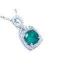 Emerald pendant with diamond accents on a right position topside view.
