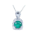 Round deep bluish-green emerald and diamond halo pendant in 18K white gold.