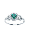 This women's ring features a Colombian emerald with a round cut, surrounded by a halo of natural diamonds.
