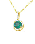 A round cut natural emerald encircled in a halo diamond pendant in yellow gold.