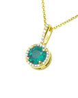 Topside view of a yellow gold emerald pendant necklace side gallery profile visible.