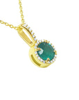 A yellow gold round cut emerald pendant necklace displaying the topside and gallery profile.
