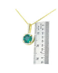 0.88 ct. round Colombian emerald pendant with halo diamonds on a 14K gold chain, next to a ruler.