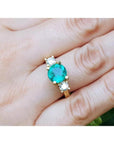 GIA certified F1 Colombian emerald three-stone ring with round diamonds in 18K yellow gold.
