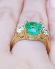 Underside profile view of a 18k yellow gold emerald ring on a hand.