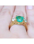 Underside profile view of a 18k yellow gold emerald ring on a hand.