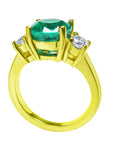 18k Yellow gold emerald round cut ring with two side diamonds, lateral position top and gallery profile.