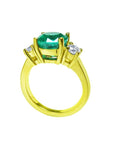 18K yellow gold three-stone ring with a GIA certified F1 Colombian emerald and two round accent diamonds.