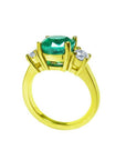 18K yellow gold three-stone ring with a GIA certified F1 Colombian emerald and two round accent diamonds.