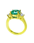 18K yellow gold three-stone ring with a GIA certified F1 Colombian emerald and two round accent diamonds.
