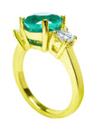 A round cut emerald and diamond ring in yellow gold, top and gallery profile visibles.