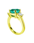 2.44 ct. GIA certified F1 Colombian emerald three-stone ring with round diamonds in 18K yellow gold.