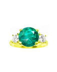 Natural round cut emerald with two side diamonds ring yellow gold, close top view on a top front position
