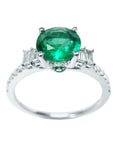 This is an affordable round cut emerald engagement ring, displaying the top and sides profile.