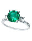 Round cut emerald ring and diamond accents on a front top position with side profile.
