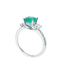 A 14k white gold emerald engagement ring on a half side displaying top gallery and shank profile.